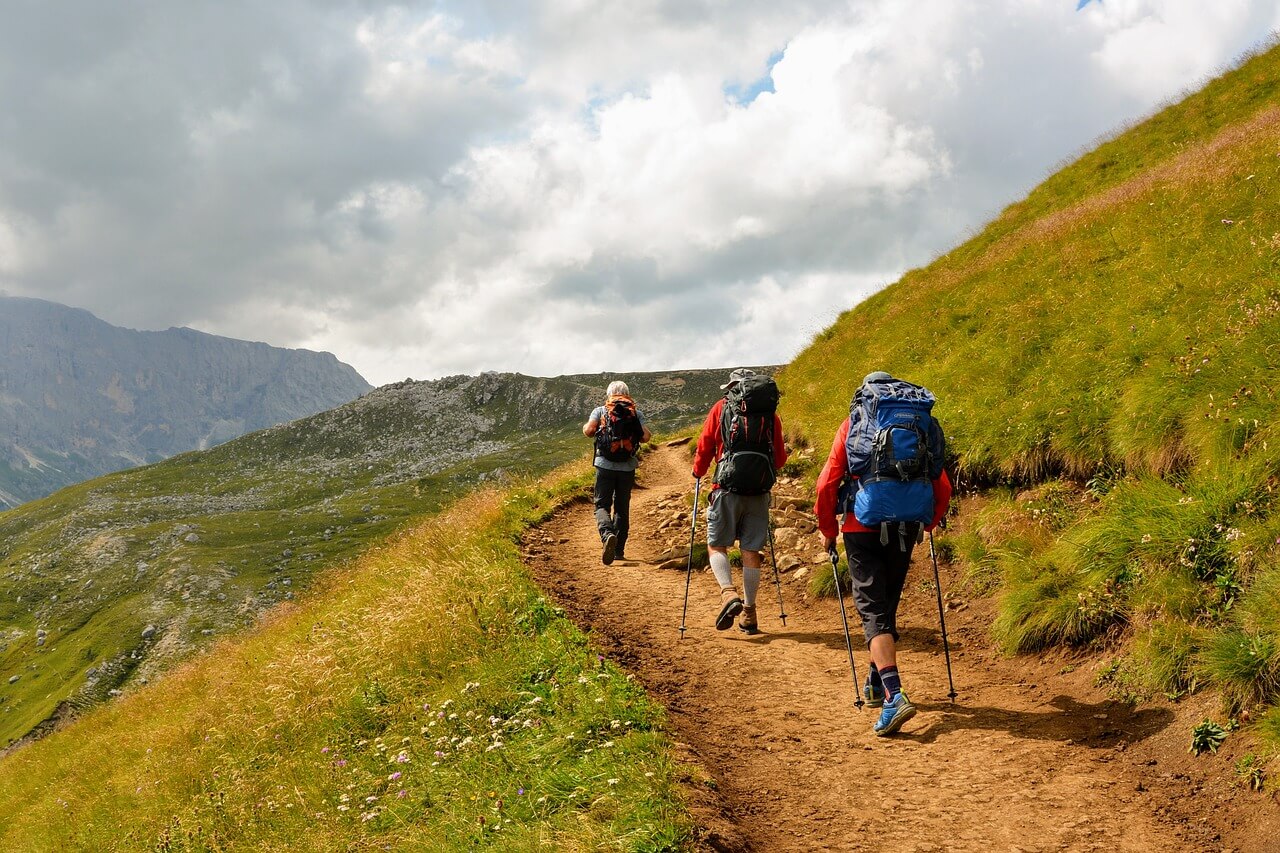 Back view of people trekking with backpacks